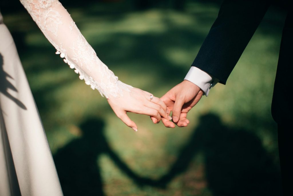 Foto de enfoque de hombre y mujer tomados de la mano