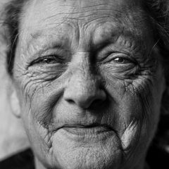 Mujer mayor sonriendo en blanco y negro