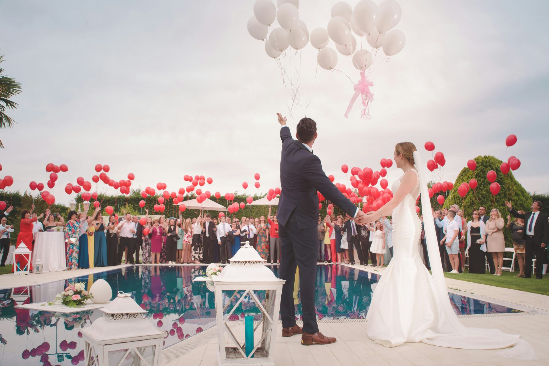 Foto de un hombre y una mujer recién casados ​​sosteniendo globos.