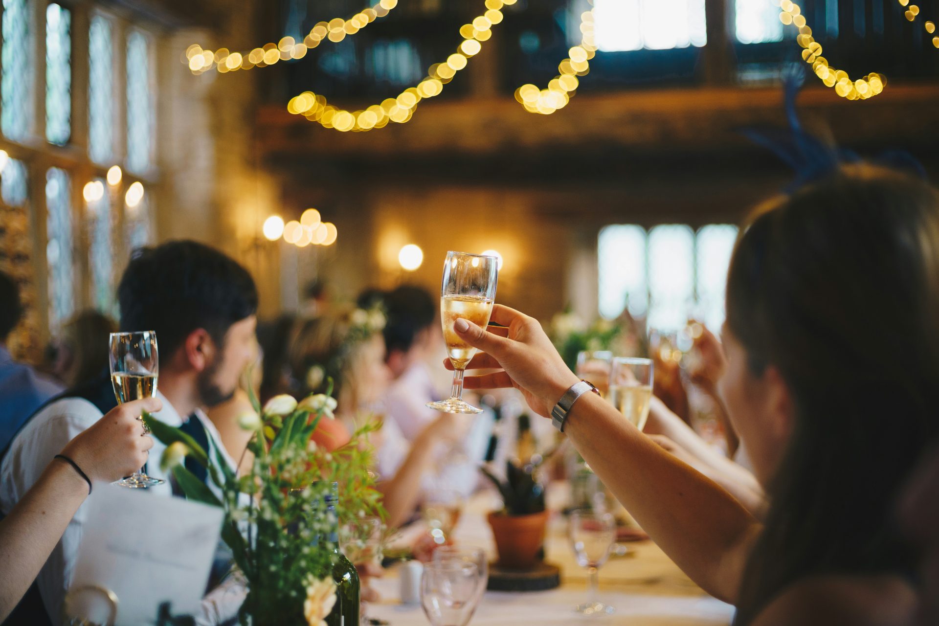 Personas levantando copas de vino en fotografía con enfoque selectivo